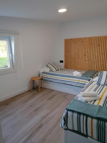 a bedroom with two beds and a window at La Veiga Romana in Tui