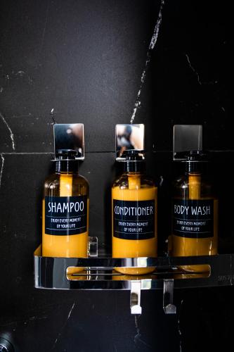 three bottles of shampoo and conditioner on a shelf at La Maison Boutique Hotel in Cao Bằng