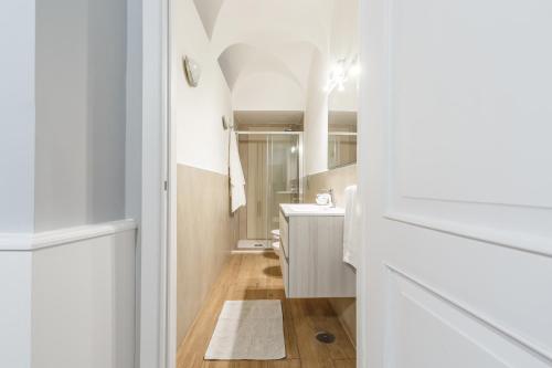 ein weißes Badezimmer mit Waschbecken und Spiegel in der Unterkunft CasAlice Apartments Roma Trevi in Rom