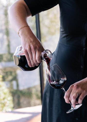 a person pouring wine into a wine glass at Auberge Ostapé in Bidarray