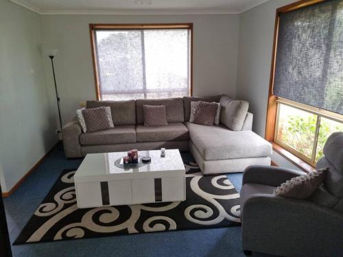 sala de estar con sofá y mesa de centro en Entire 3 Bedroom Home With Driveway Space for Caravan or Boat en Portland