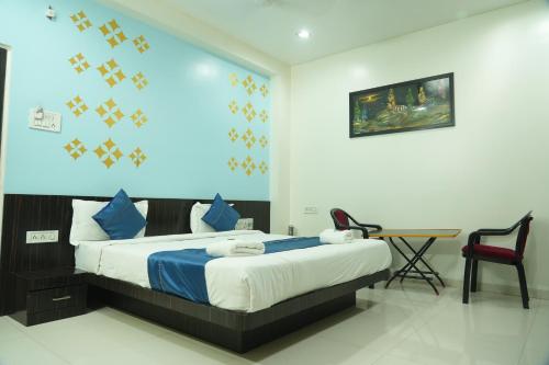 1 dormitorio con 1 cama, mesa y sillas en Hotel Avon International, en Aurangabad