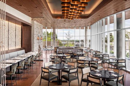a restaurant with tables and chairs and large windows at Hyatt Centric Beale Street Memphis in Memphis