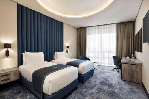 a hotel room with two beds and a window at Wyndham Garden Baku in Baku