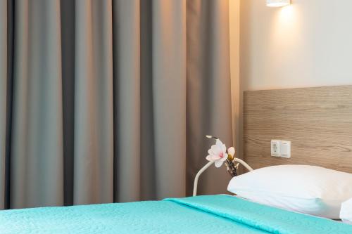 a bed with a pillow and a flower on it at Zefyros Sea View Hotel in Platamonas