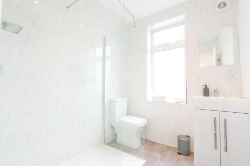 a white bathroom with a toilet and a sink at Lovely 3 bedroom property in Filton in Bristol