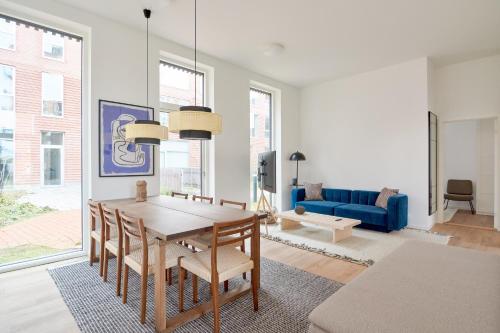 uma sala de estar com uma mesa e um sofá azul em Great Apt · Near Beach · CPH em Copenhague