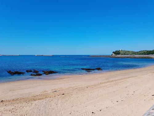 uma praia com água azul e pedras na areia em Sagardi Zolan em Saint-Jean-de-Luz