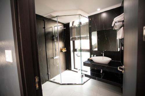 a bathroom with a glass shower and a sink at La Maison Boutique Hotel in Cao Bằng
