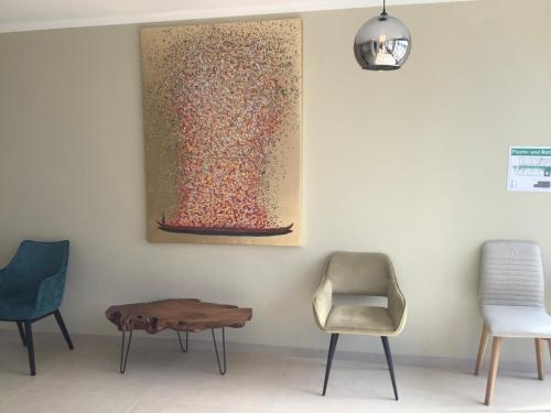 アウクスブルクにあるHotel A8 Lukasの椅子と壁画のある部屋