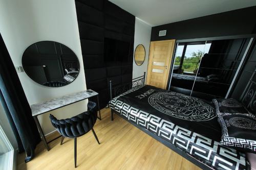 a bedroom with a black bed and a mirror at Apartament Gdynia Arena in Gdynia