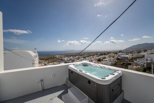 a hot tub on the balcony of a house at Cycladic Suites & Spa in Fira