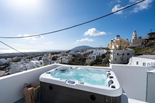 a hot tub on the balcony of a house at Cycladic Suites & Spa in Fira