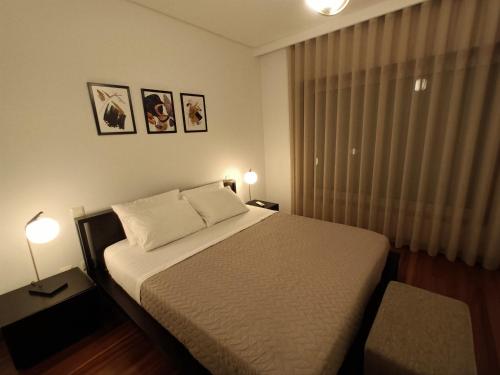 um quarto com uma cama com 2 candeeiros e uma janela em Casa de Ribes T2 Vista Fantástica em Rio Caldo