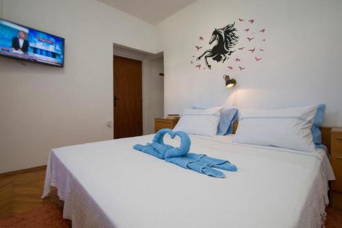 - une chambre avec un lit et une serviette bleue dans l'établissement Apartman Bačić, à Vela Luka