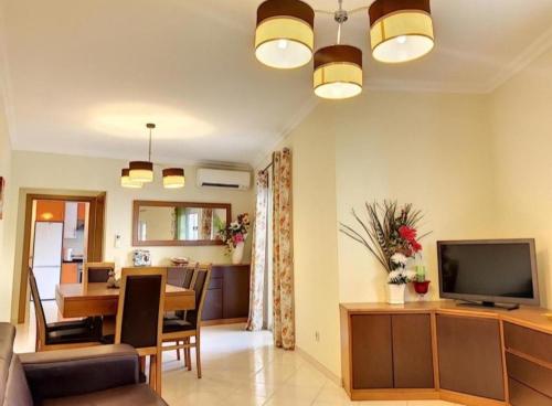 een woonkamer met een televisie en een eetkamer bij Candyland Apartment in Albufeira