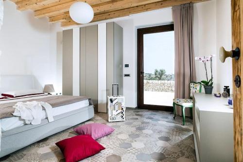 una camera da letto con un letto con cuscini rosa sul pavimento di Villa Balate - Countryside Luxury Experience a Ragusa