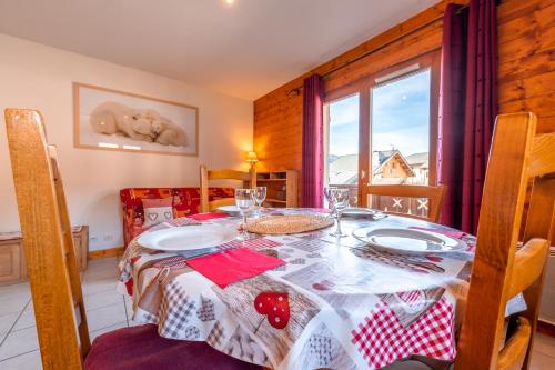 een eetkamer met een tafel en een raam bij Le Chatellard - Proche Piste de Ski in Praz-sur-Arly