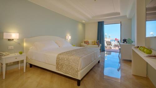 a bedroom with a bed and a view of the ocean at Hellenia Yachting Hotel & SPA in Giardini Naxos