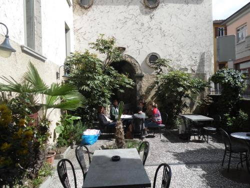 a group of people sitting at tables in a courtyard at Garni Bar Sport in Mendrisio