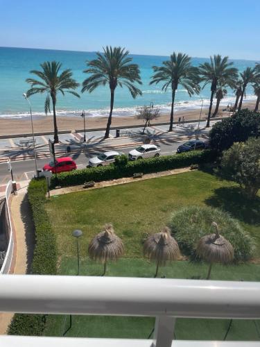 a view of a beach and palm trees from a balcony at Benicasim Primera Linea Vistas al Mar in Benicàssim