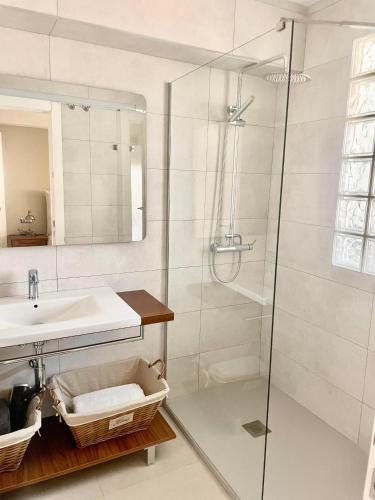 a bathroom with a glass shower and a sink at Benicasim Primera Linea Vistas al Mar in Benicàssim