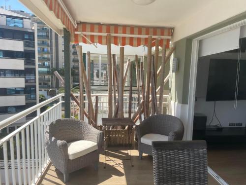 a balcony with two chairs and a tv and a window at Benicasim Primera Linea Vistas al Mar in Benicàssim