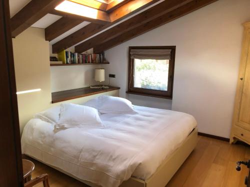 a bedroom with a large white bed with a window at Alveluu ristorante e suites in Tremezzo