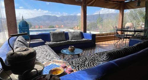 a living room with couches and a view of the mountains at Camping Auberge Zebra in Ouzoud