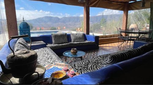 a living room with couches and a view of the mountains at Camping Auberge Zebra in Ouzoud