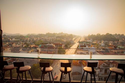 a view of a city from a balcony with stools at La Maison Boutique Hotel in Cao Bằng
