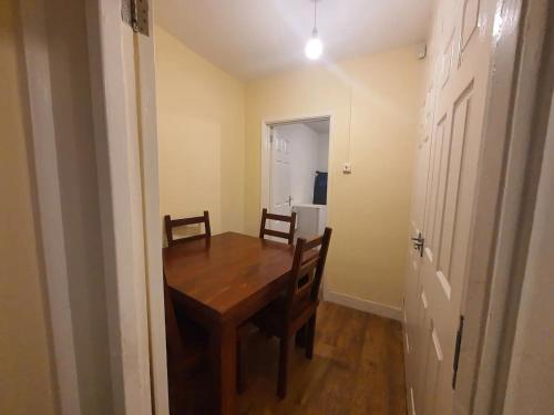 uma sala de jantar com uma mesa de madeira e 2 cadeiras em Spacious Double Bedroom Manchester em Middleton