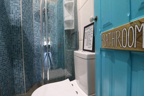 uma casa de banho com um WC e uma cabina de duche em vidro. em International Surf School & Camp em Sagres