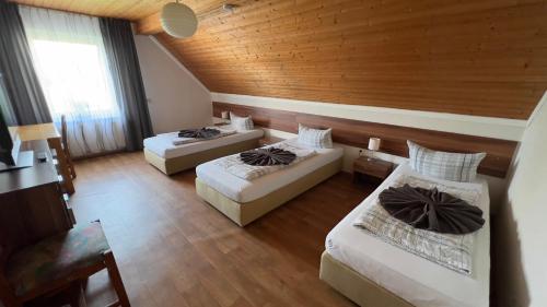 Cette chambre dispose de deux lits et d'un plafond en bois. dans l'établissement Pension Reiter, à Blomberg