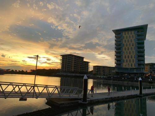 a person walking on a bridge over a body of water at Oceania at Darwin Waterfront in Darwin