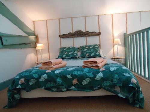 een slaapkamer met een bed met een groen dekbed bij Au bord de Thau in Marseillan
