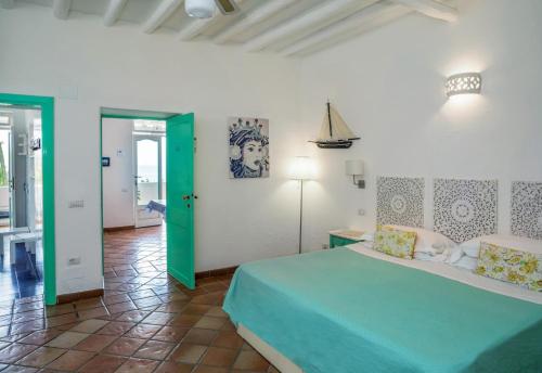 a bedroom with a bed and a green door at Villa Mareblu Luxury Holiday Apartment direttamente sul mare in Stromboli