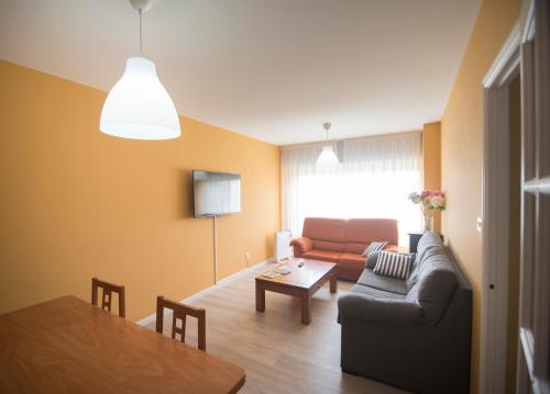 a living room with a couch and a table at AMPLIO APARTAMENTO EN BURELA in Burela de Cabo