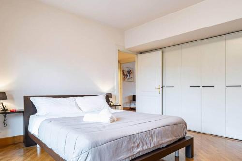 a bedroom with a white bed with a cat sitting on it at Broletto Park Apartment - Affitti Brevi Italia in Lecco