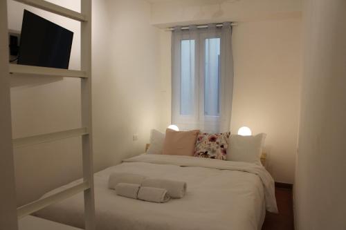 a bedroom with a bed with white sheets and a window at Friends of Michelangelo in Florence