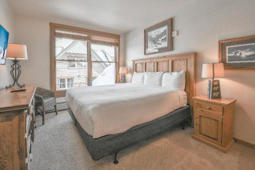 Schlafzimmer mit einem Bett, einem Schreibtisch und einem Fenster in der Unterkunft Black Bear 8052 in Keystone
