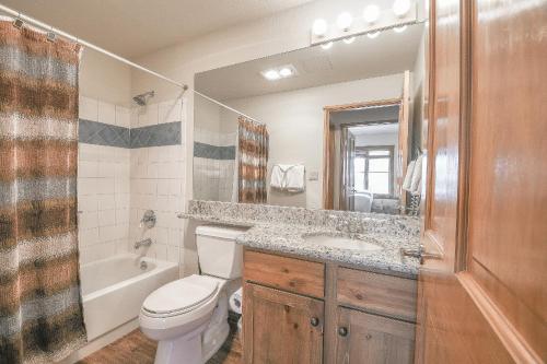 ein Badezimmer mit einem WC, einem Waschbecken und einem Spiegel in der Unterkunft Black Bear 8052 in Keystone