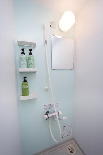a bathroom with a shower with a mirror and a sink at Ebisu Ryokan in Kyoto
