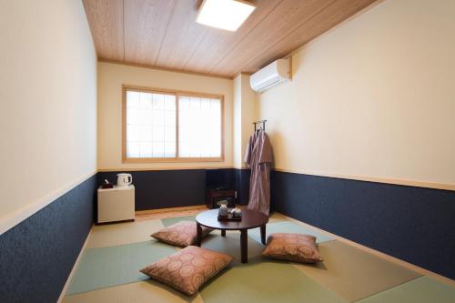 Habitación con 2 sillas, mesa y ventana en Ebisu Ryokan, en Kioto