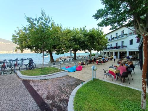 a group of people sitting at tables by the water at Hotel S.Maria in Brenzone sul Garda