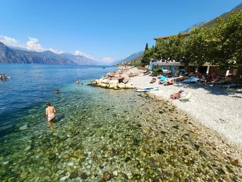 a man standing in the water at a beach at Hotel S.Maria in Brenzone sul Garda