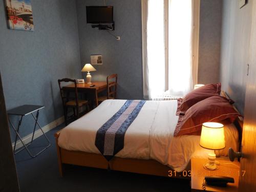 Un pat sau paturi într-o cameră la Hôtel le Petit Château proche parc des expositions porte de versailles