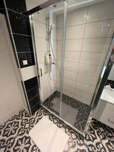 une douche avec une porte vitrée dans une salle de bain dans l'établissement Le Sunny-hyper centre -proche gare - Paisible -WIFI HD -NETFLIX-Idéal couple business et famille, à Niort