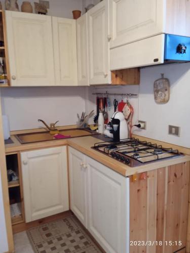 a kitchen with white cabinets and a stove top oven at residence orione in Caspoggio