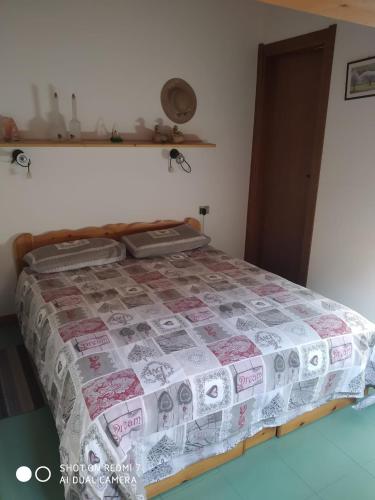 een bed in een kamer met een sprei met geld erop bij residence orione in Caspoggio